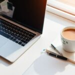 A bright workspace with a laptop and notepad.